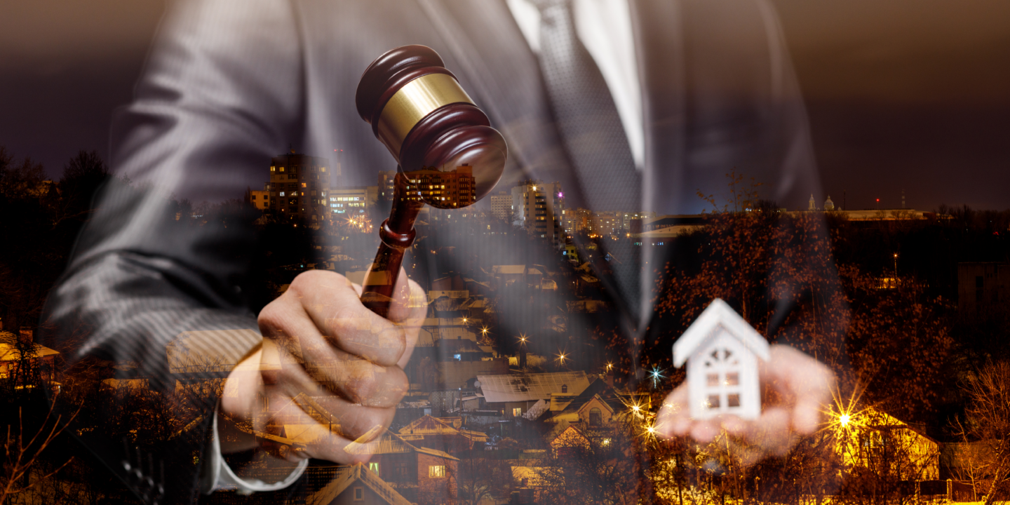 A man holding a gavel with houses in the background