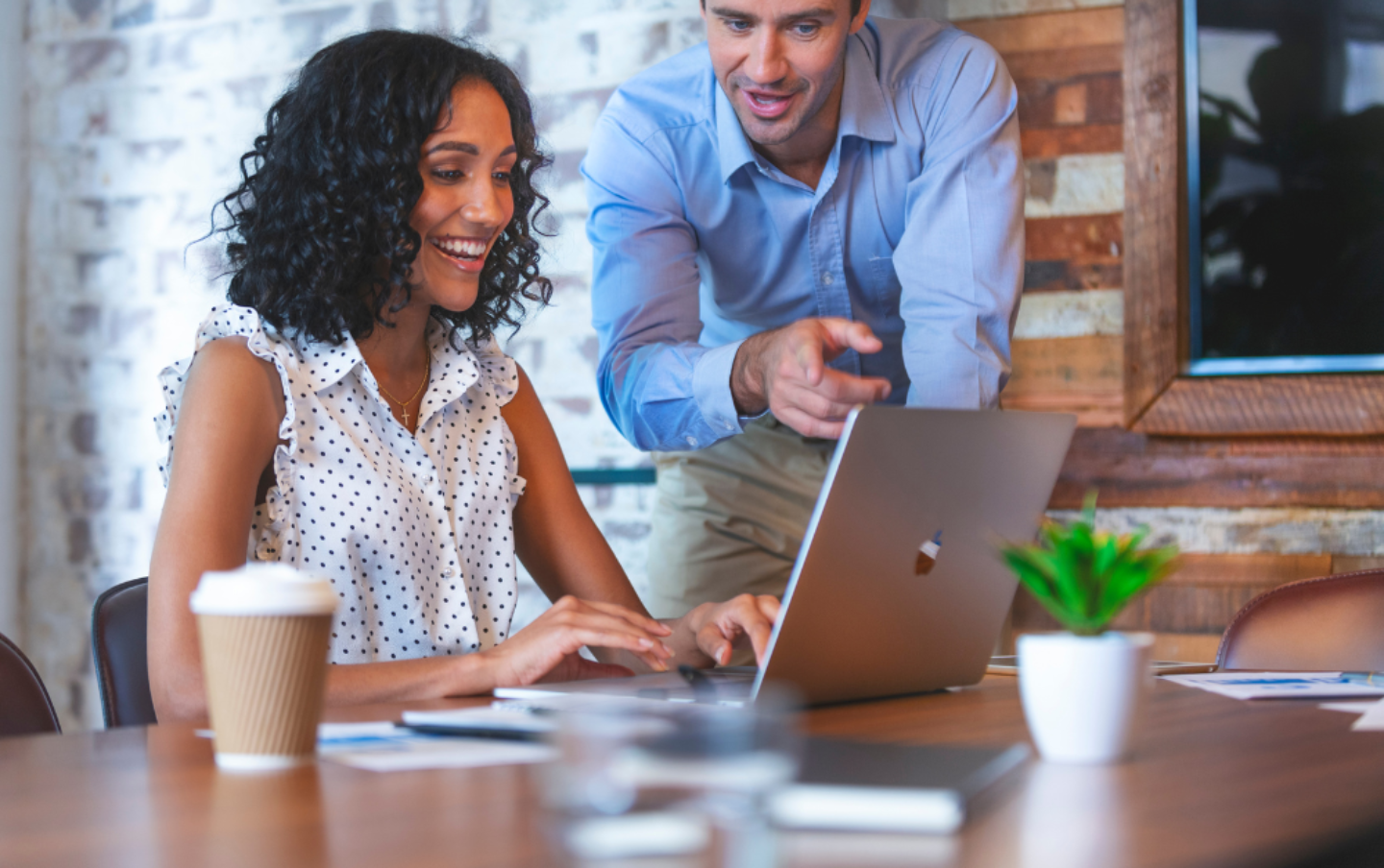 A man and woman looking at a laptop screen