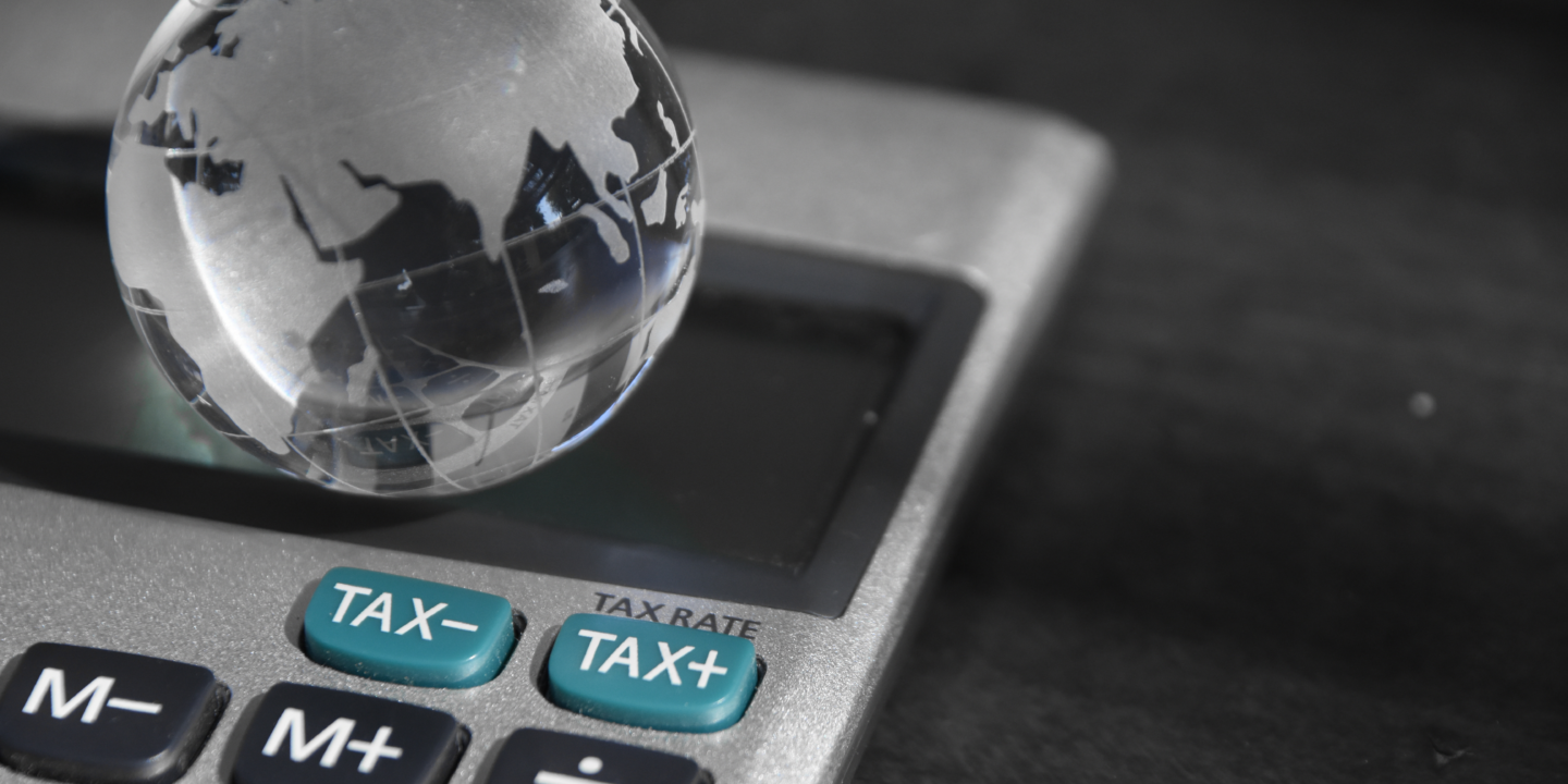 A tax calculator with a globe positioned on top