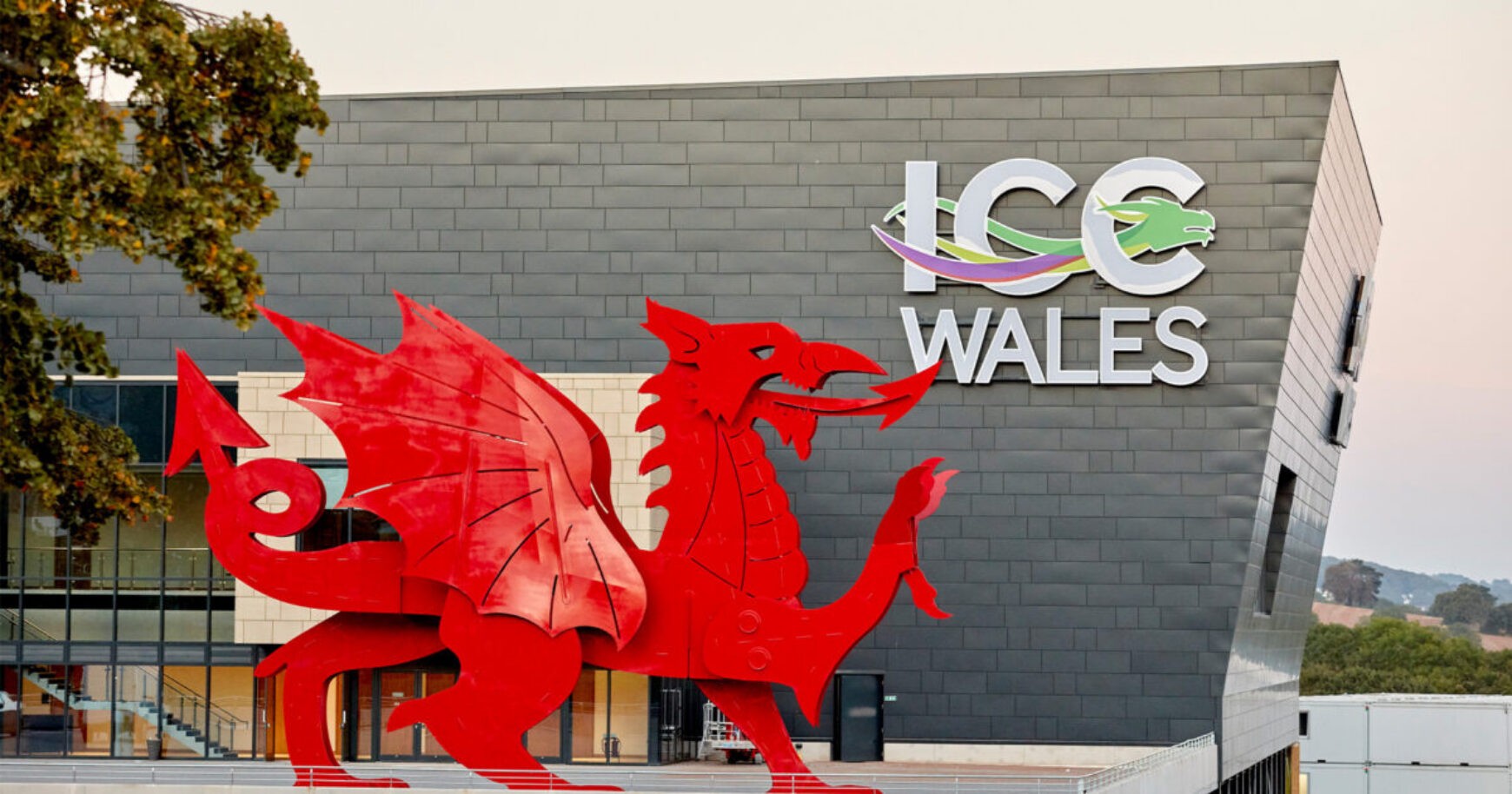 A large red dragon sculpture in front of the ICC Wales building.